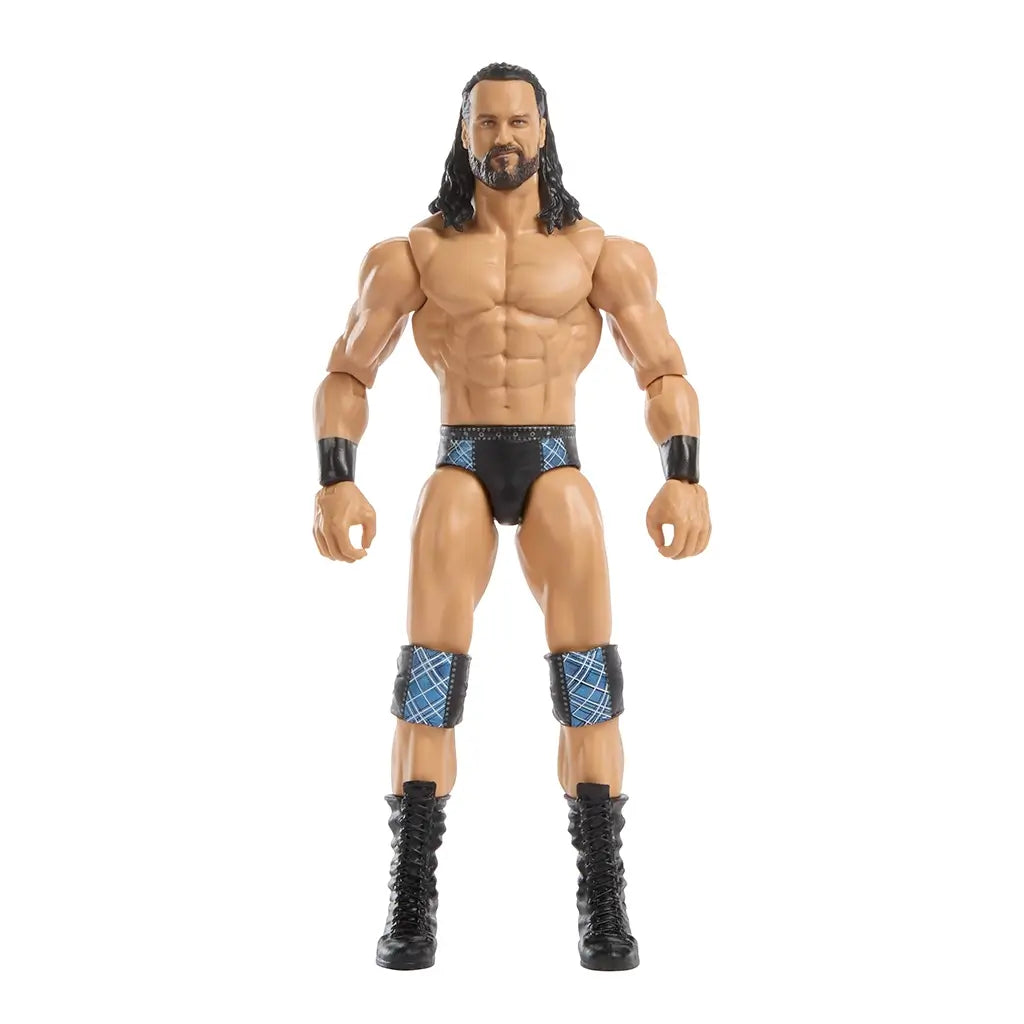 WWE Drew McIntyre action figure featuring tan plastic skin tone, muscular sculpted physique, long black hair, black trunks with blue accents, knee pads, wristbands, and black boots, designed as a 6-inch poseable wrestling figure on white.