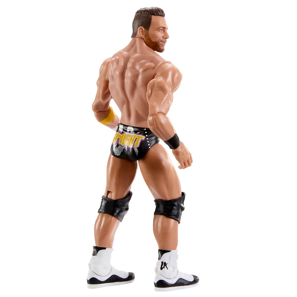 WWE Main Event Series LA Knight wrestling figure rear angled view highlighting sculpted back muscles, black trunks with gold LA Knight logo, short brown molded hair, black knee pads, white boots, and articulated limbs on a white background.