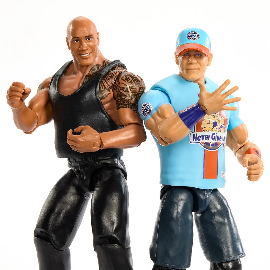 Close-up of WWE Main Event Showdown figures of The Rock in black gear with tattoos and John Cena in blue 'Never Give Up' shirt, posed side by side in wrestling stances.