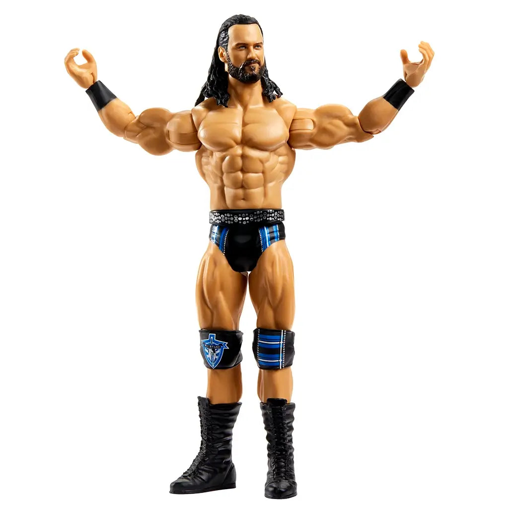 WWE Drew McIntyre action figure posed with arms raised, wearing black boots, trunks, and blue-accented knee pads, designed for display or play.