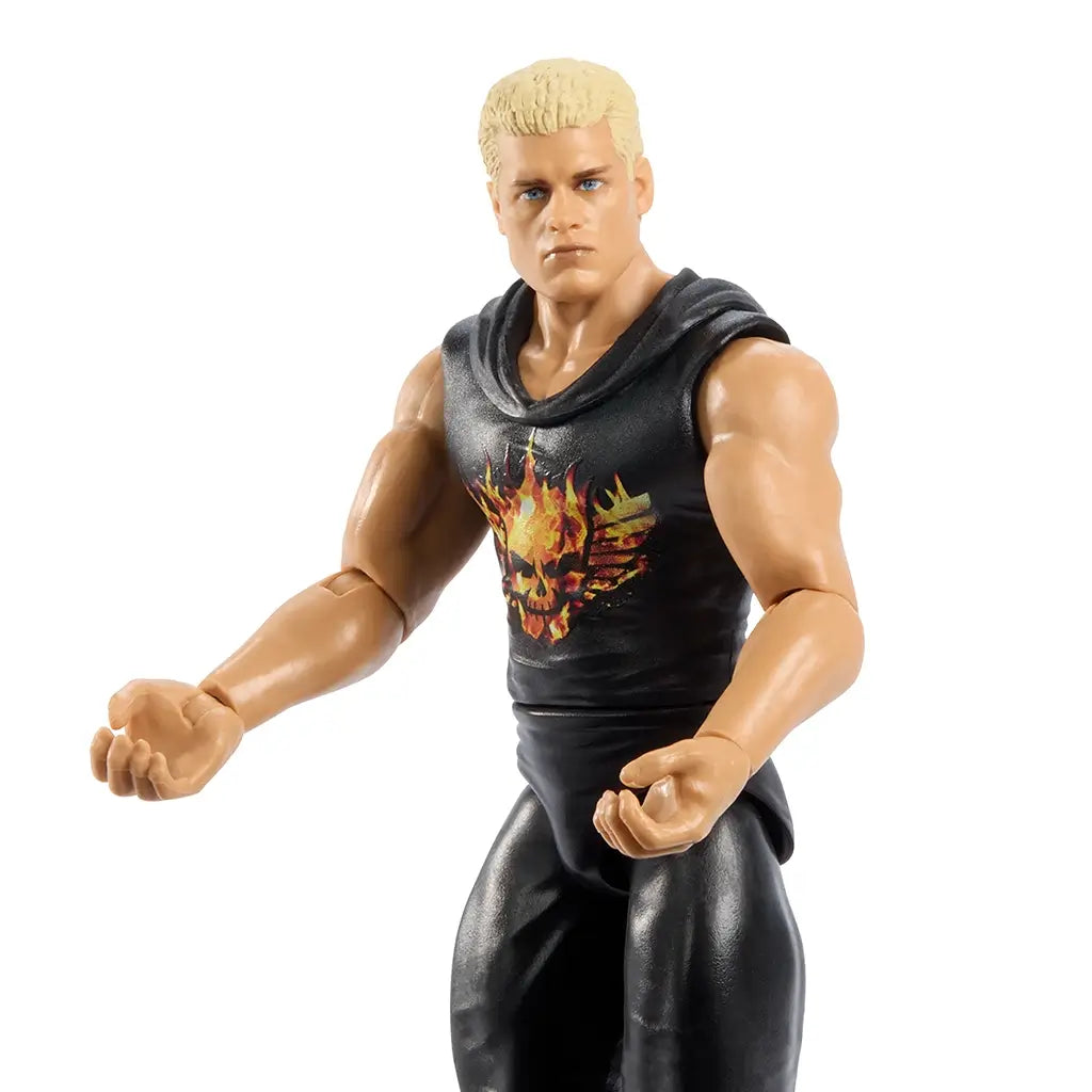Close-up of WWE Cody Rhodes action figure in black attire with flaming skull chest design, showing muscular arms, blond hair, and detailed facial sculpt against white background.