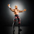 WWE Solo Sikoa action figure posed with arms raised, detailed tattoos, black shorts with red tribal graphics, knee pads, and black boots on a reflective surface.