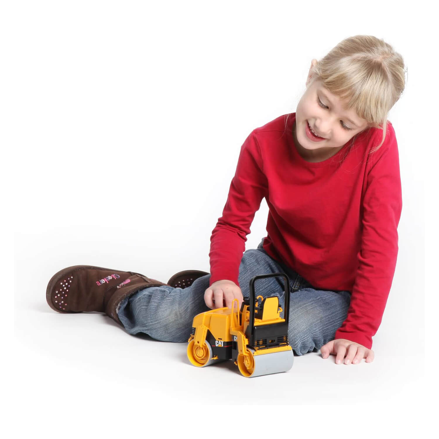 Child playing with the asphalt drum compactor toy.