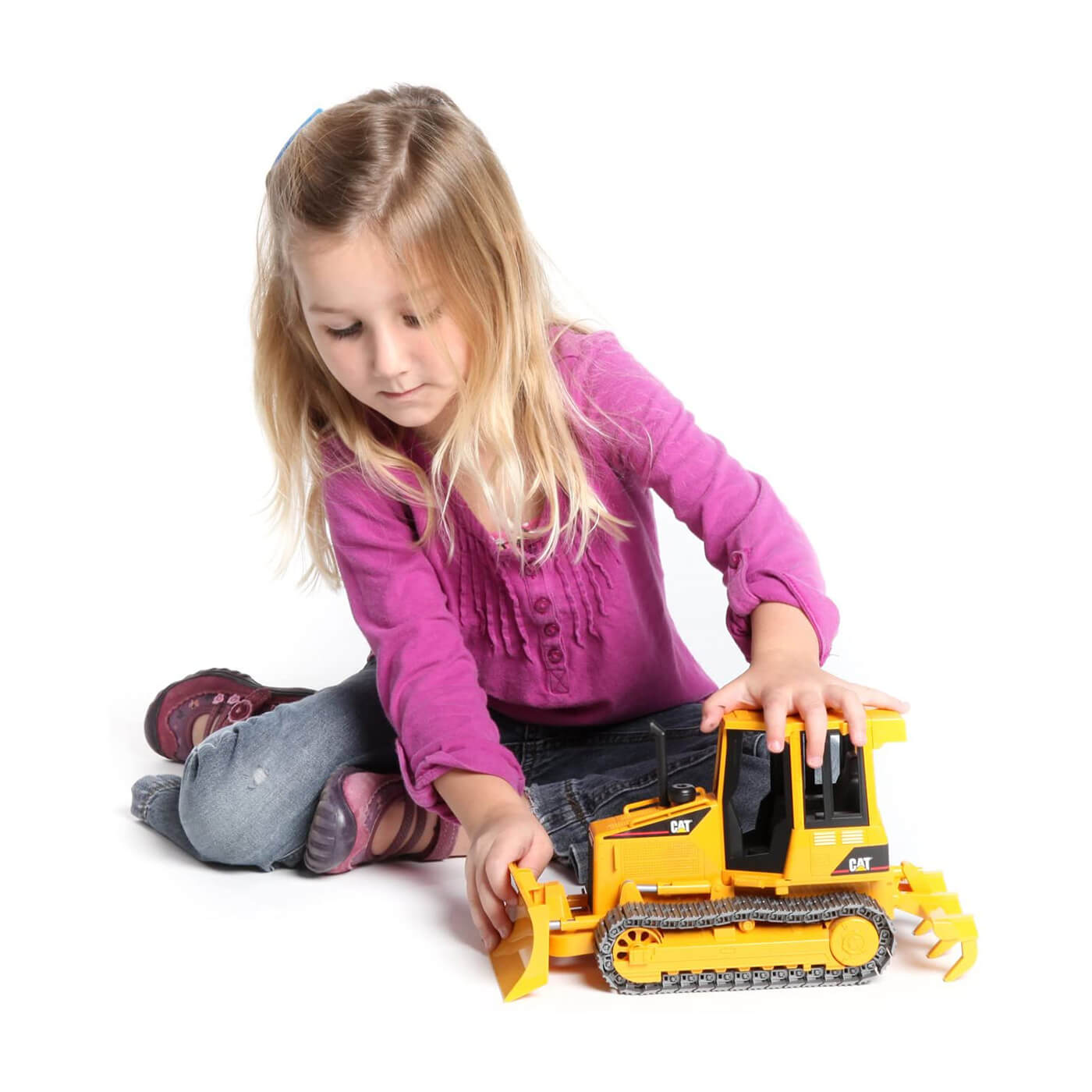 Kid playing with the tractor vehicle toy.