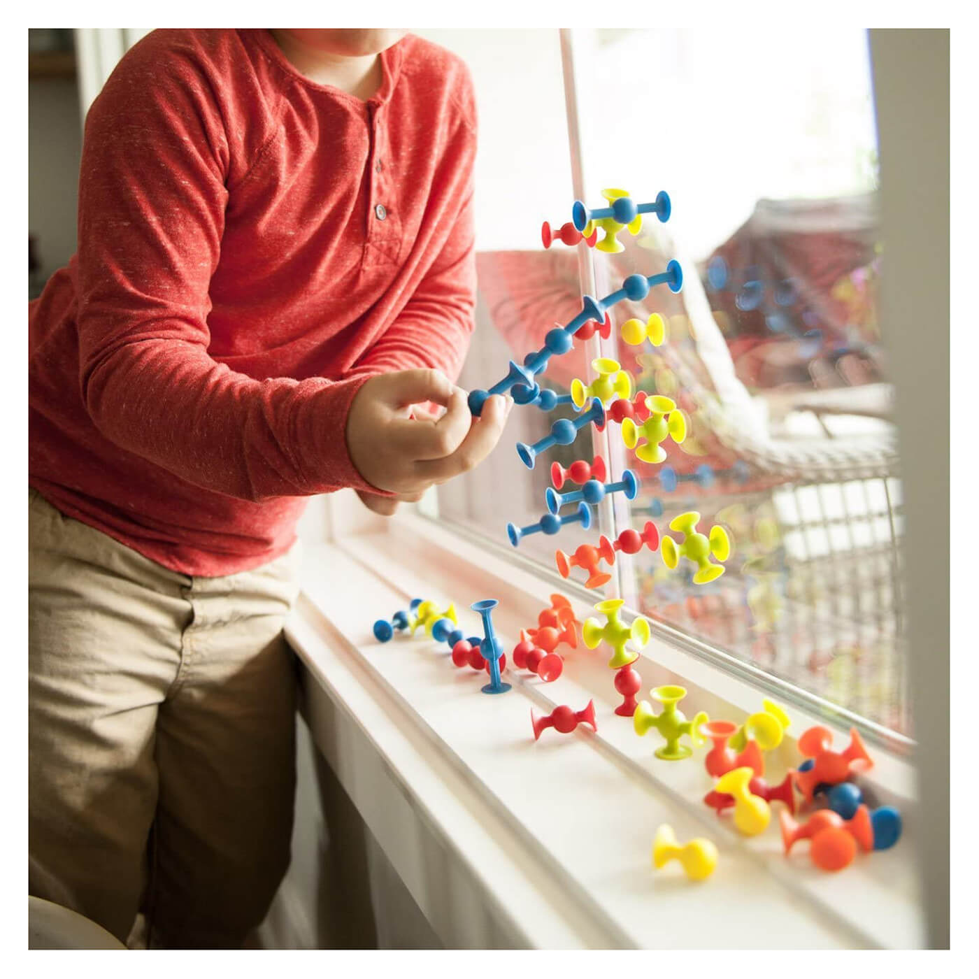 Kid sticking the toy to glass.