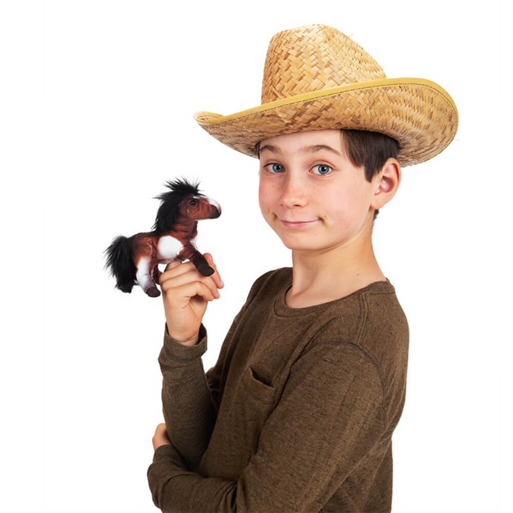 Boy dressed like a cowboy in a straw had is playing with the Folkmanis Mini Horse Finger Puppet.
