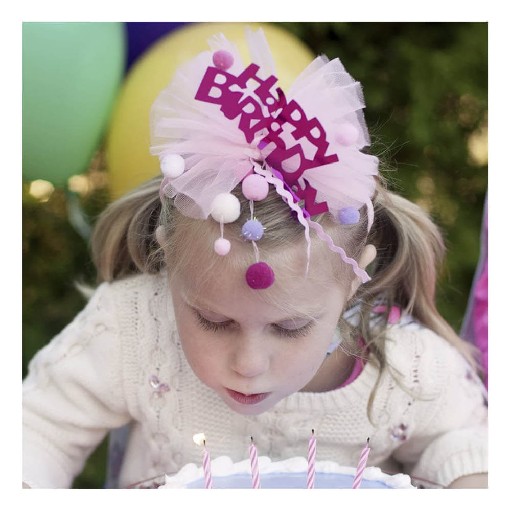Front view of little girl wearing the Great Pretenders Happy Birthday Headband.