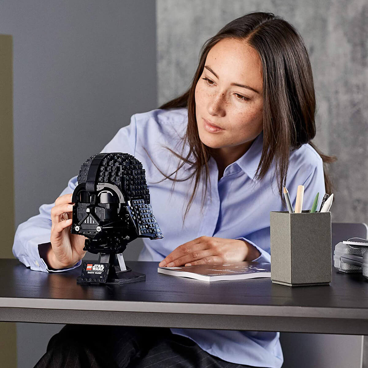 Woman building the LEGO Darth Vader Helmet