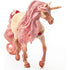 Schleich bayala decorated unicorn mare figure has a cream textured coat, glittery pink flowing mane and tail, golden horn, and floral accents, shown stepping forward on a white background.