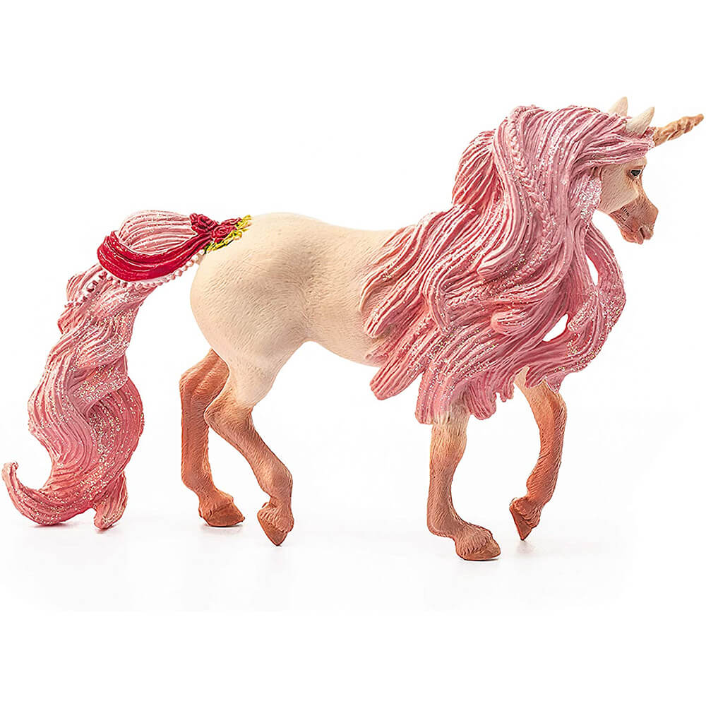 Schleich bayala unicorn mare toy features a cream-colored textured body, long sparkling pink mane and tail, gold spiral horn, and red floral ornaments in side view on white.